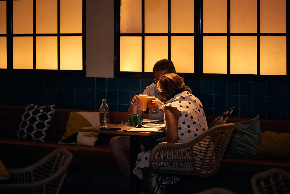 Event photography of two people drinking beers at a Barcelona restaurant