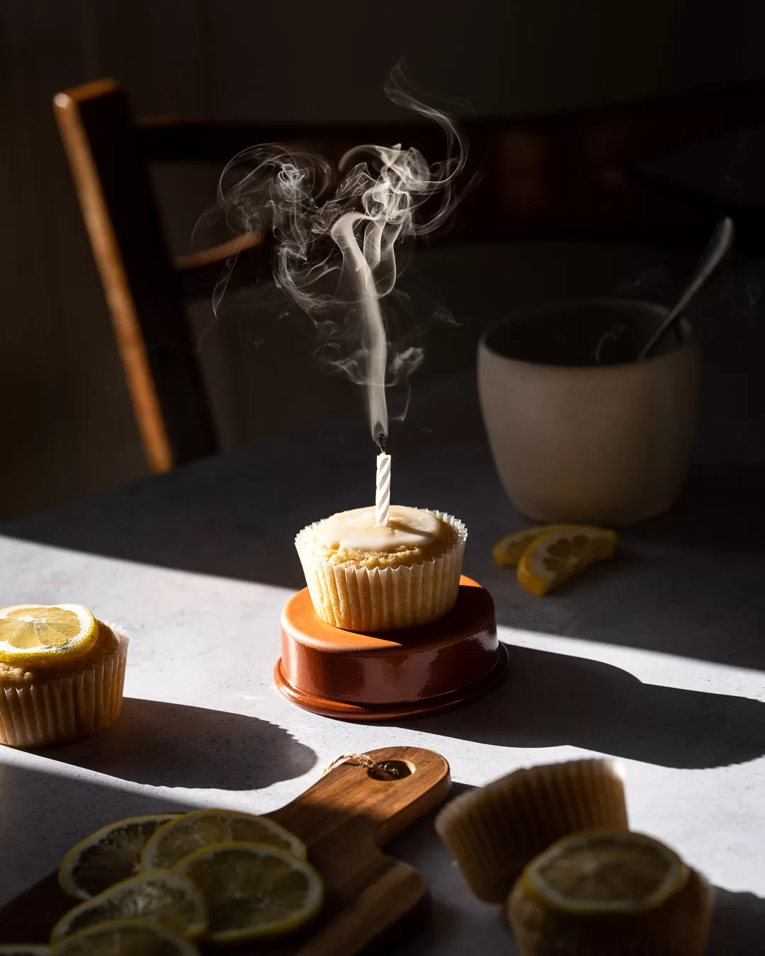 Food photo of lemon cupcake with icing and smoke from candle